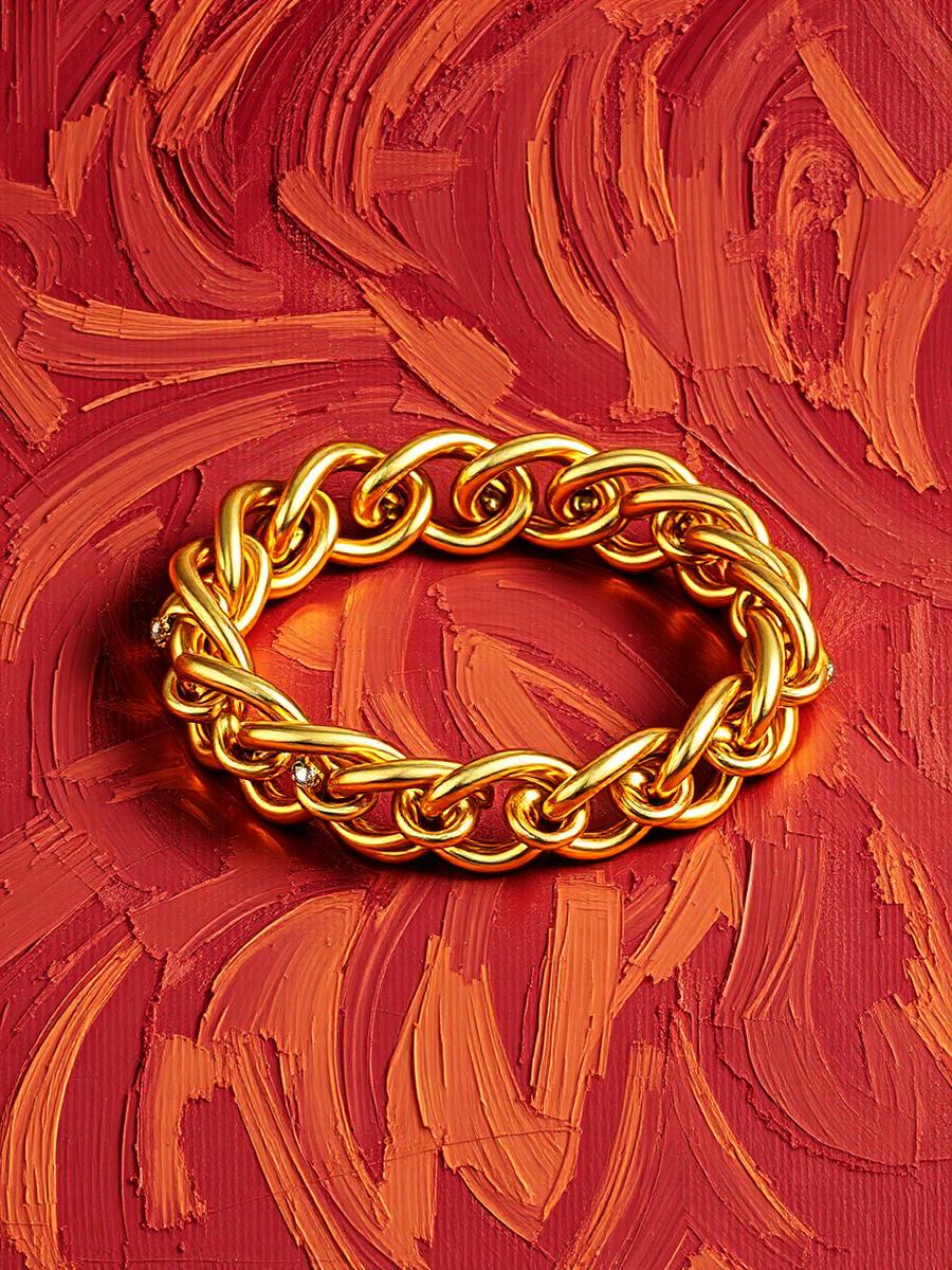 Pulseira corrente dourada com elos sobre veludo bordô